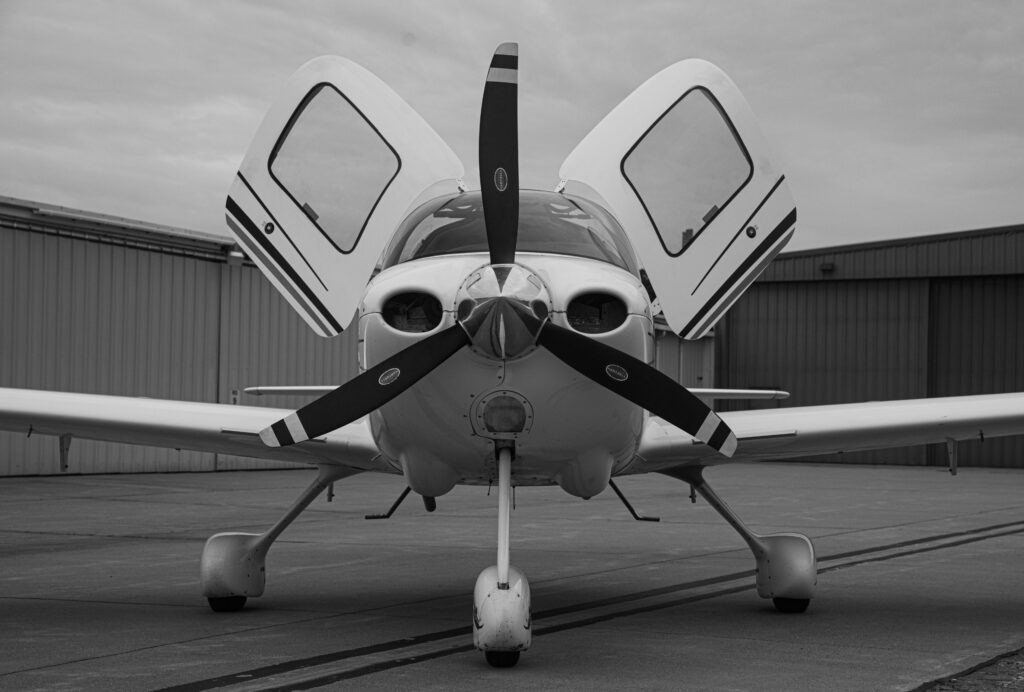 Piston aircraft with cowling open on the ramp outside a West Texas hangar serviced by AJ Aviation Services